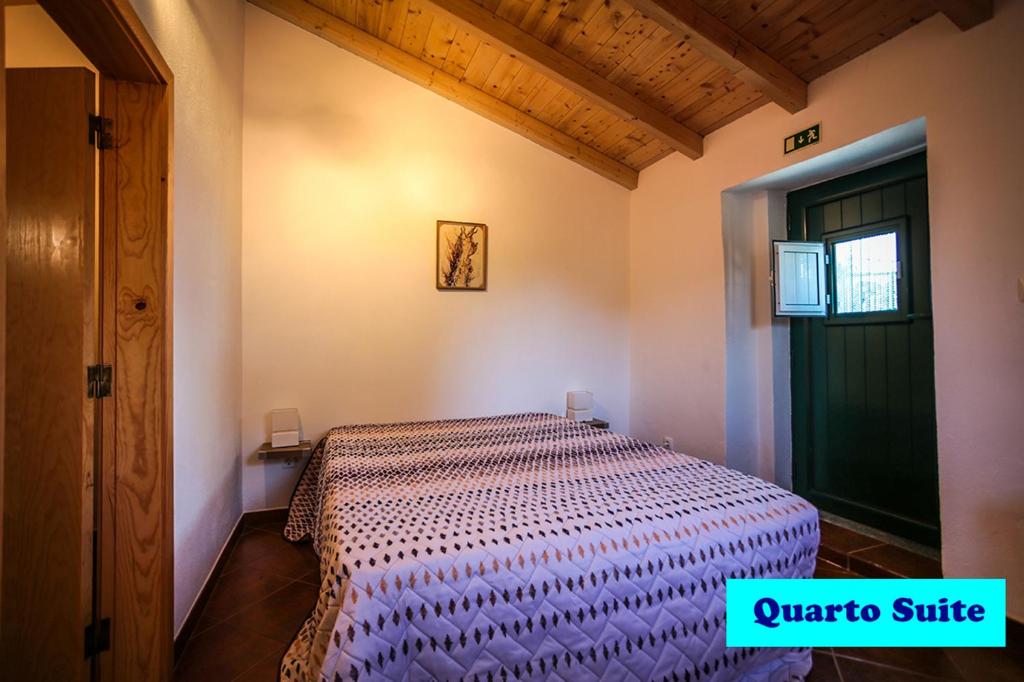 a bedroom with a bed with a purple comforter at Suite da Casa da Avó in Marvão