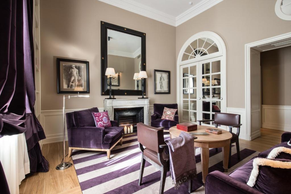 a living room with purple furniture and a mirror at Palazzo Vecchietti - Residenza D'Epoca in Florence