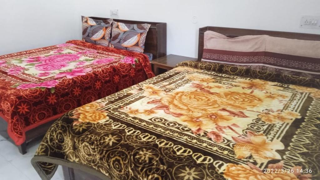 two beds sitting next to each other in a room at Shri Badrivishal -A mata Hotel in Badrīnāth