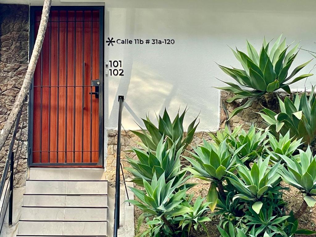una porta rossa su un edificio con alcune piante di Lalinde by Wynwood House a Medellín