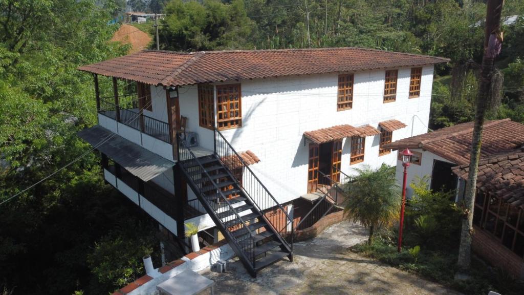 a house with a spiral staircase in front of it at Xplora Hostel in Caldas