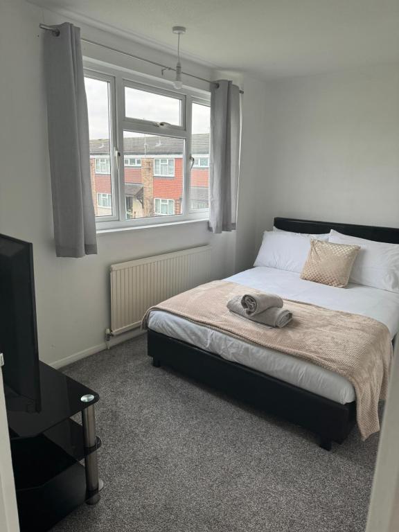 um quarto com uma cama e uma televisão em Spacious Comfortable 4 Bedroom House! em Aylesbury