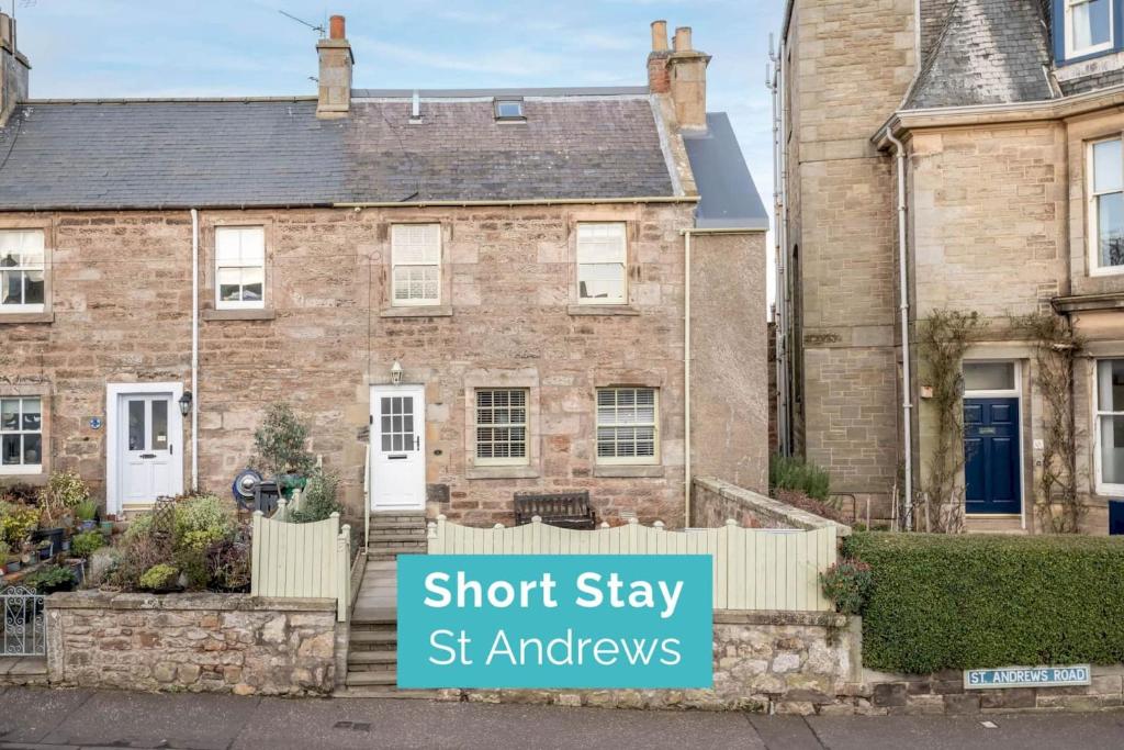 a brick house with a sign that reads short stay st ambassadors at Crail Town House - Sleeps 6 in Crail