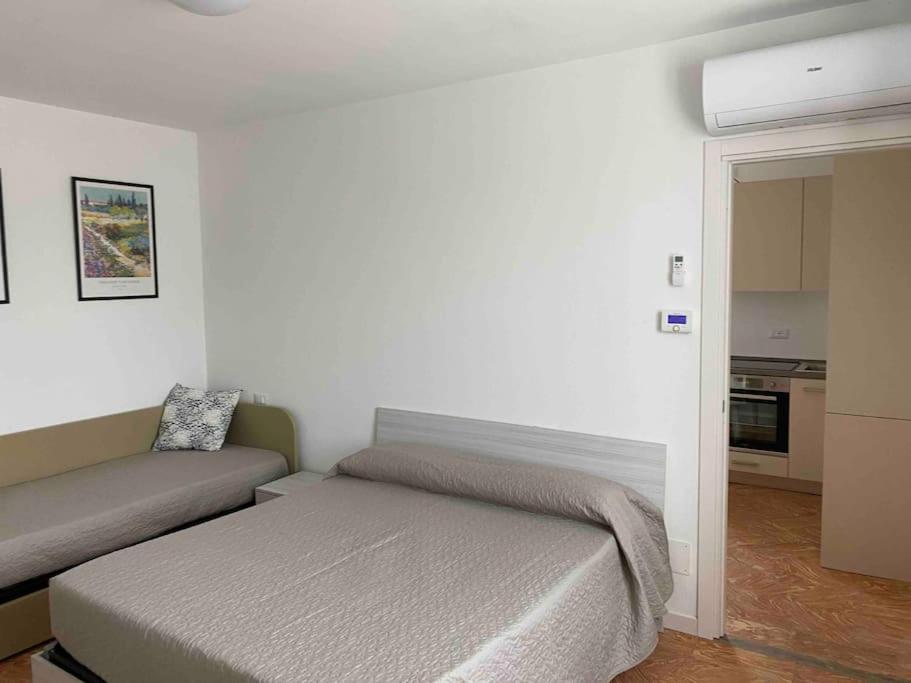ein kleines Schlafzimmer mit einem Bett und einem Sofa in der Unterkunft Cozy Escape in Bellagio in Bellagio