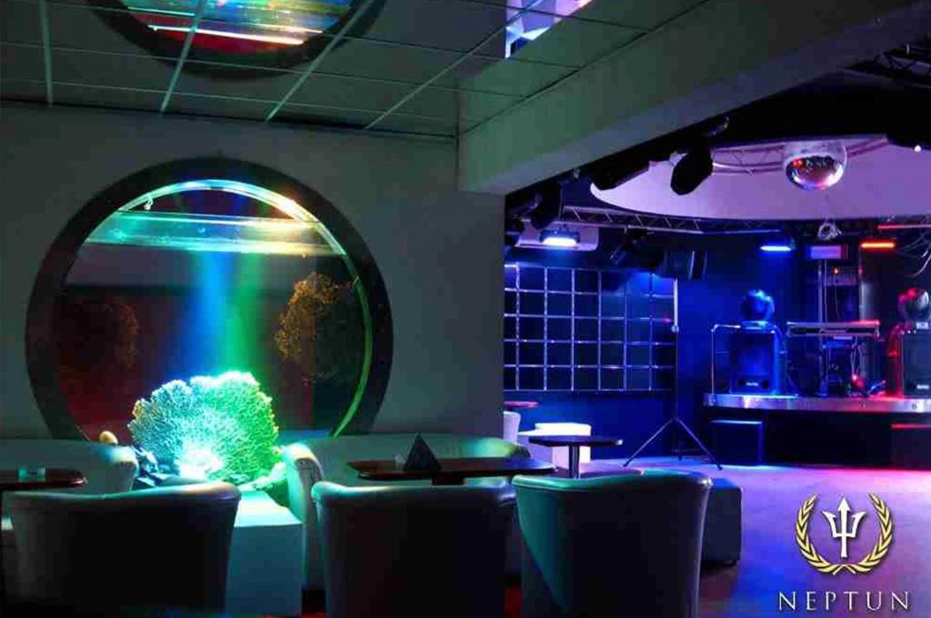 a room with a aquarium with chairs and a table at Hotel & Restaurant - Jastrzębia Góra in Rozewie