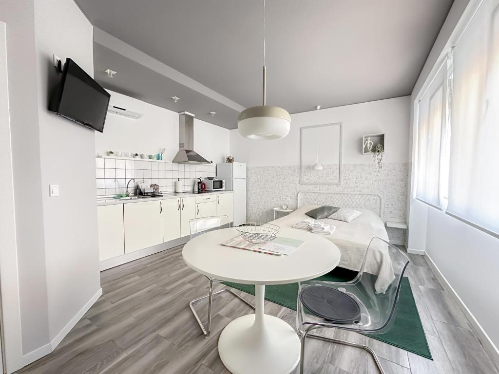 a white kitchen with a white table and chairs at Budget Inn in Valencia