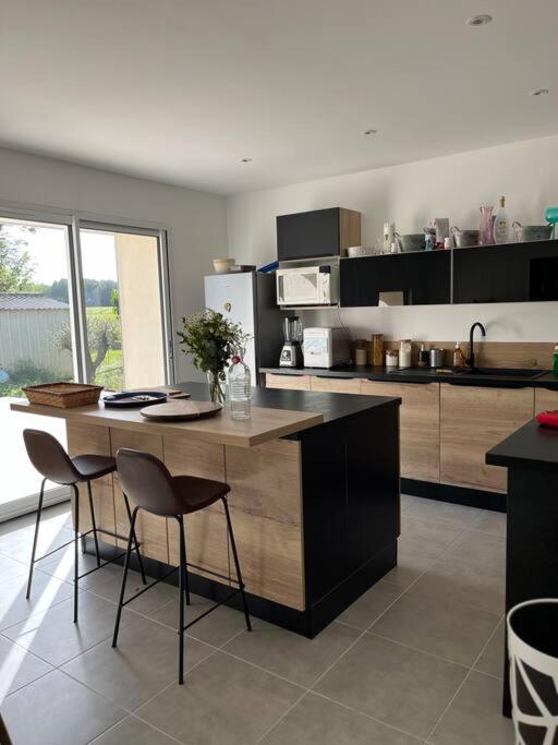 - une cuisine avec deux chaises et un îlot dans la chambre dans l'établissement Petit cocon au cœur du médoc, à Saint-Estèphe