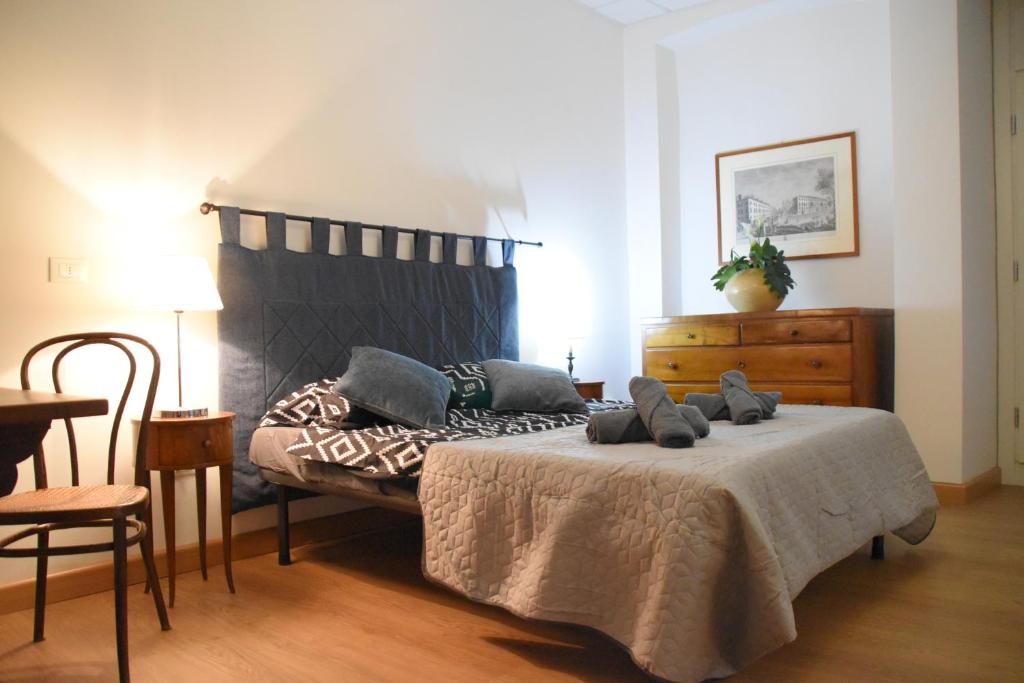 a bedroom with a bed and a table and a dresser at Loft in centro con parcheggio in Trieste