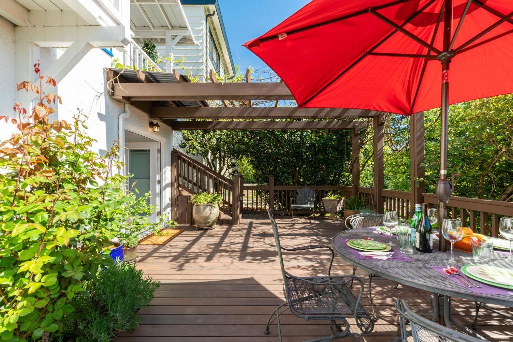 - une table avec un parasol rouge sur la terrasse dans l'établissement Laurelhurst - Cozy 1 Bedroom Apt Near Children’s Hospital and UW, à Seattle