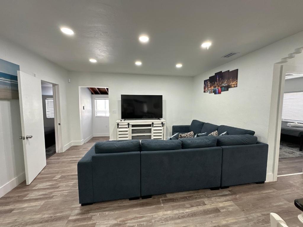 ein Wohnzimmer mit einem Sofa und einem Flachbild-TV in der Unterkunft Entire 3/1 house near Wynwood! in Miami