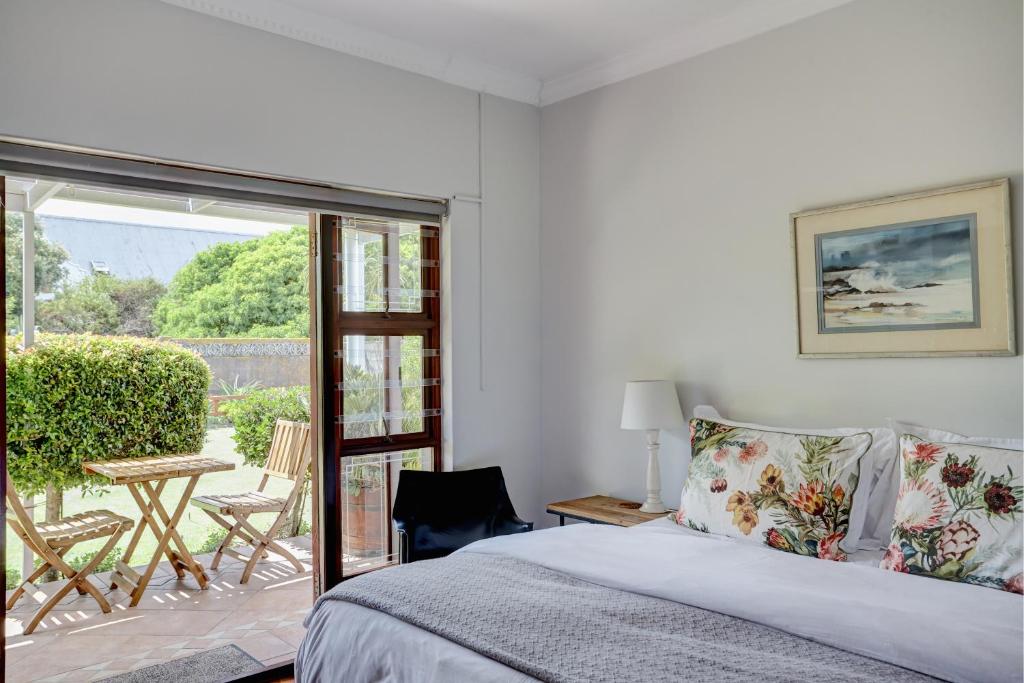 a bedroom with a bed and a sliding glass door at Beautiful Abalone in Hermanus