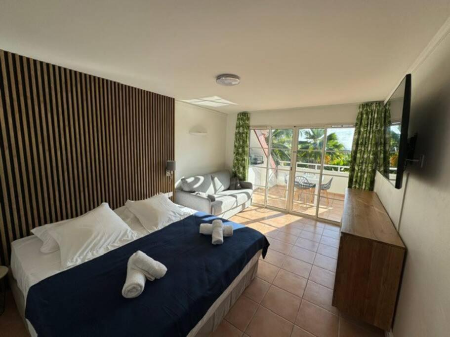 ein Schlafzimmer mit einem Bett mit zwei Handtüchern darauf in der Unterkunft Studio Bruni Lodge in Sainte-Anne