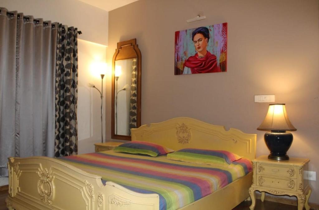 una camera con letto, specchio e lampada di Luxury retreat with golf view a Hinjewadi