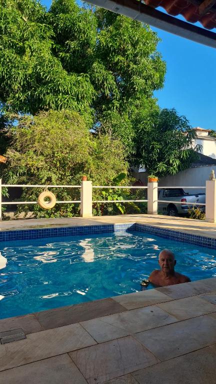 un hombre tendido en una piscina en Geribá Residence, en Búzios