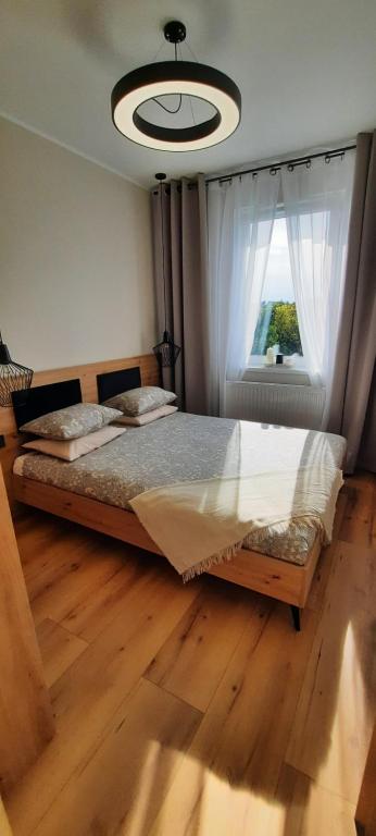 sypialnia z dużym łóżkiem i oknem w obiekcie Asti Apartamenty Centrum Stargard w mieście Stargard