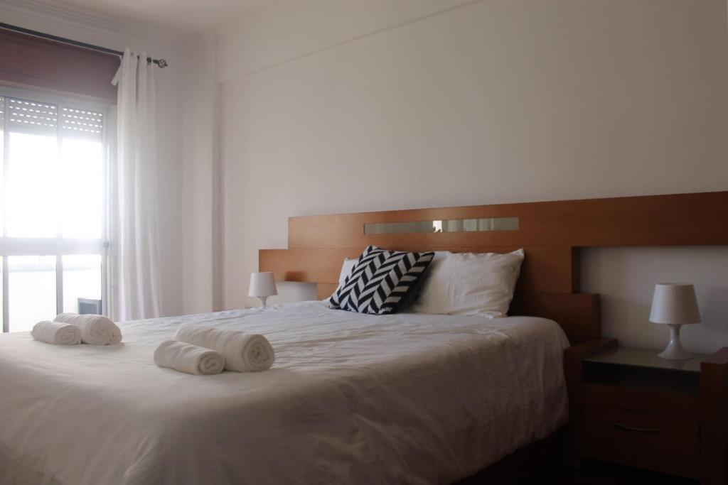 a bedroom with a large white bed with towels on it at Apartment 2BR in Queluz