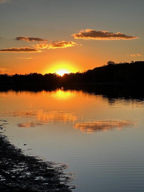 a sunset over a lake with the sun setting at POCONOS BRAND NEW LAKEFRONT Oasis 1 ACRE, HOTTUB GAMEROOM FIREPITS TALK ABOUT PRIVACY in Albrightsville
