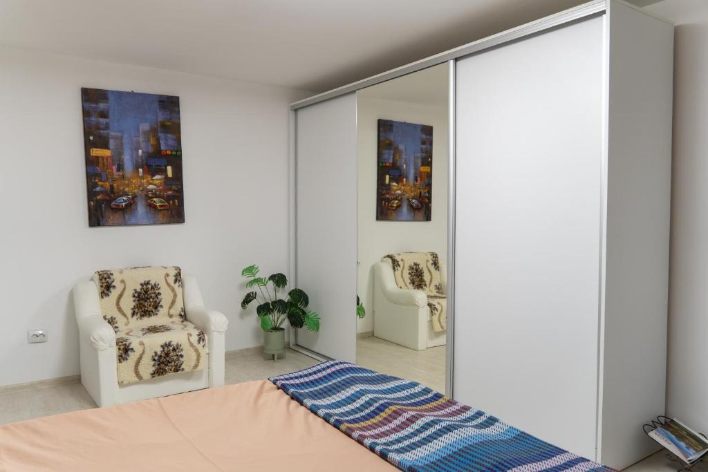 a bedroom with a mirror and two chairs at Apartament Lucas in Brad