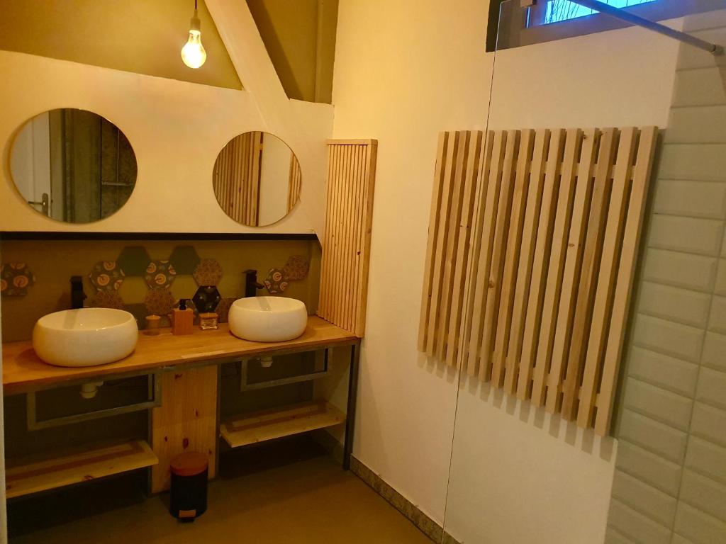 a bathroom with two sinks and two mirrors at Chambres d&#39;Hôtes du Domaine de Bourbacoup in Tulle