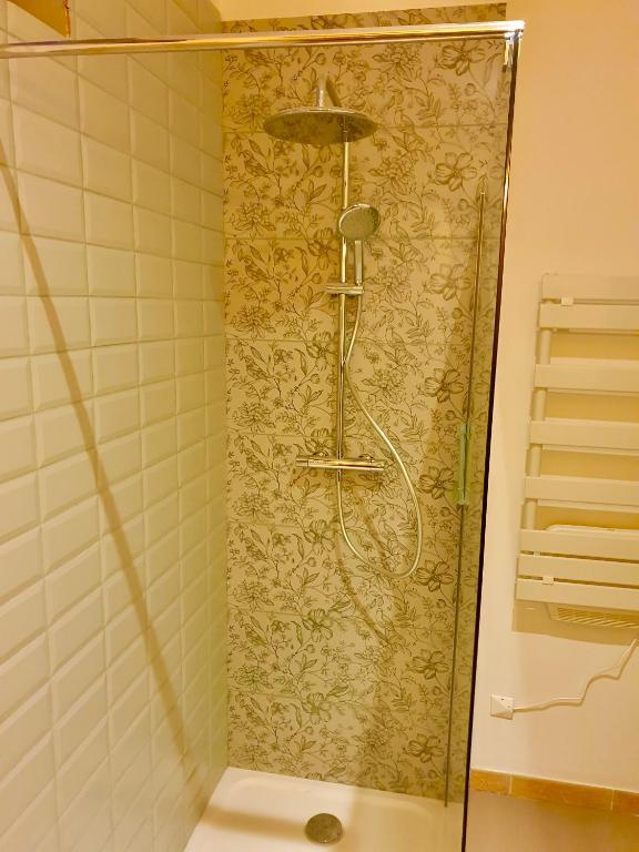 a shower in a bathroom with a tiled wall at Chambres d&#39;Hôtes du Domaine de Bourbacoup in Tulle