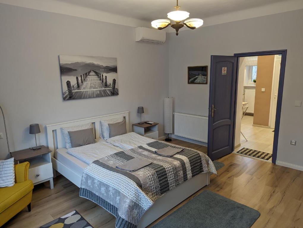 a bedroom with a bed and a painting on the wall at Várfal apartman in Kőszeg