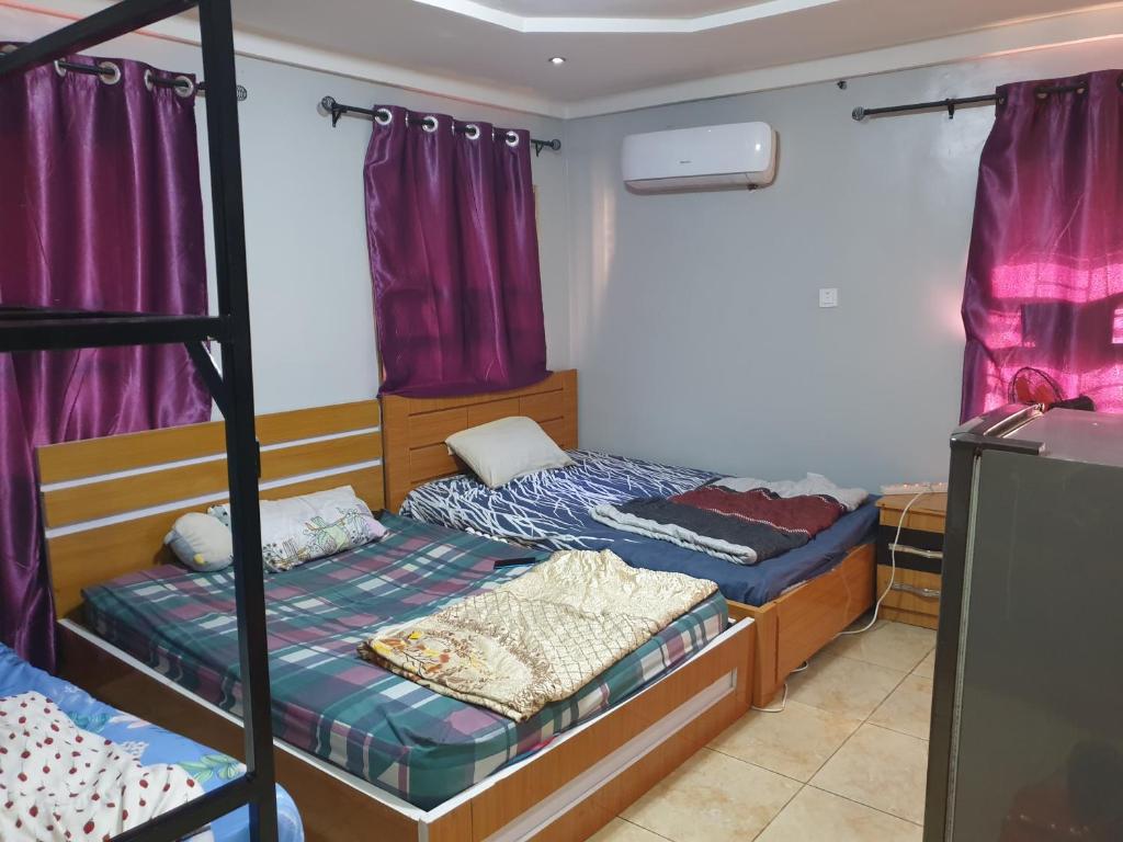 a bedroom with two bunk beds and purple curtains at Shared space accommodation in Wupa