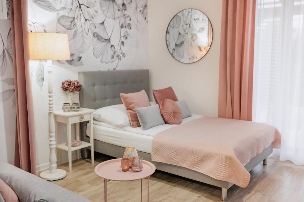 ein Schlafzimmer mit einem Bett, einem Sofa und einem Tisch in der Unterkunft APARTEMENTY ''WERANDA'' z ogrodem w centrum in Kudowa-Zdrój