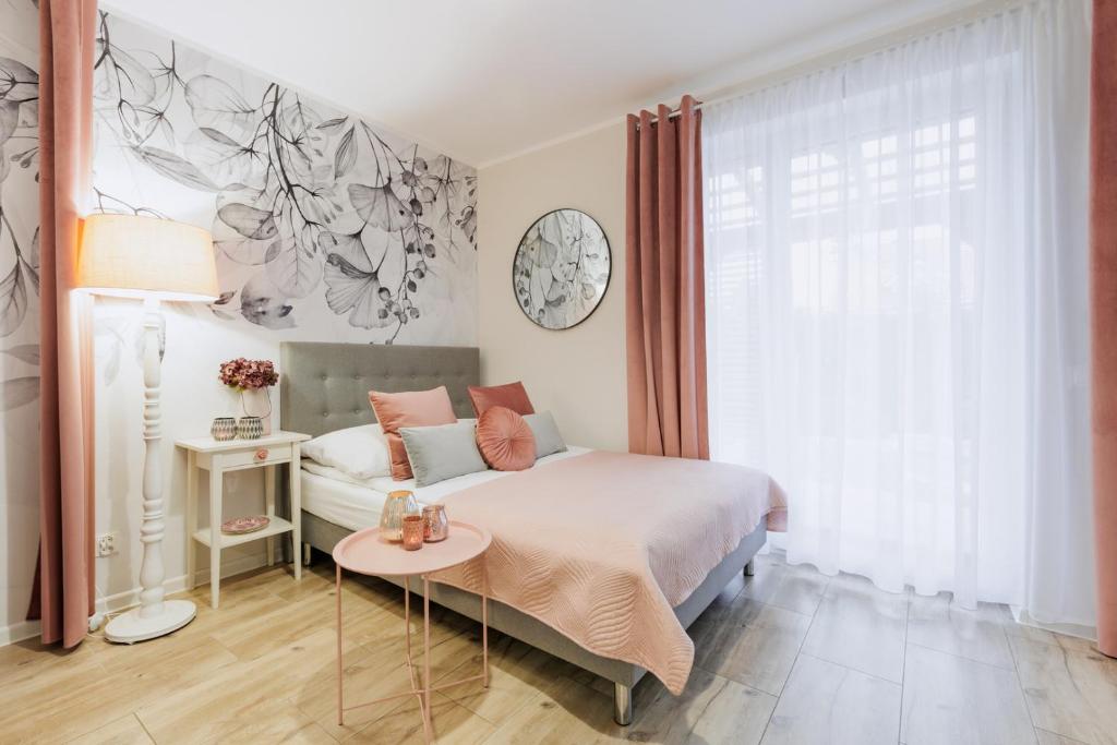 Postel nebo postele na pokoji v ubytování APARTEMENTY ''WERANDA'' z ogrodem w centrum