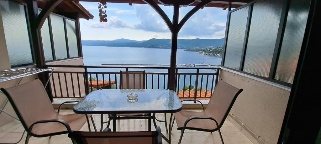 a table and chairs on a balcony with a view of the water at Pyrgadikia Paradise in Pyrgadikia