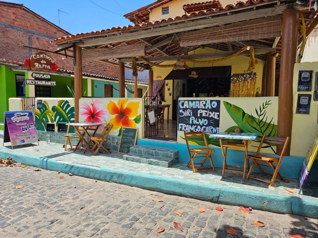een restaurant met tafels en stoelen voor een gebouw bij Cantinho da Rapha in Ilha de Boipeba