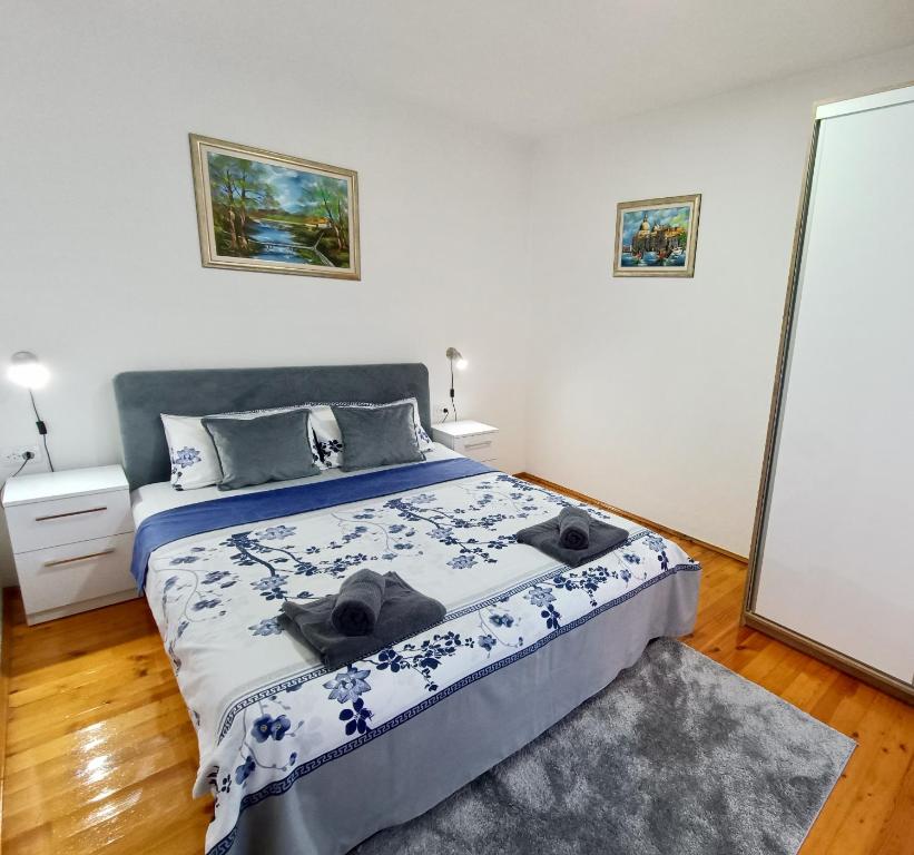 Schlafzimmer mit einem Bett mit einer blauen und weißen Bettdecke in der Unterkunft Entire house floor - 2-Bedroom Cozy & Peaceful Apartment in Podgorica