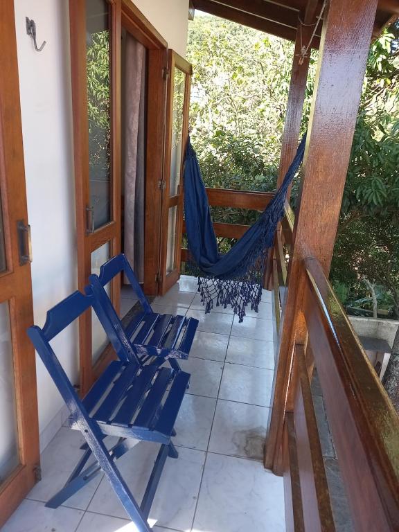 eine Veranda mit 2 Stühlen und einer Hängematte in der Unterkunft Recanto da Lagoa in Florianópolis