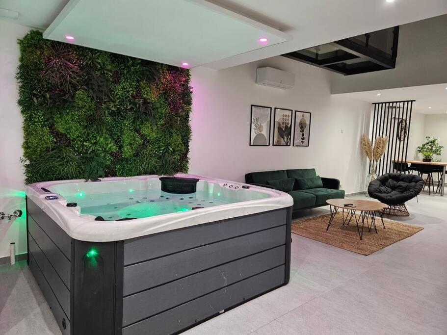 a hot tub in a living room with a green wall at Spa des ducs loft 2 in Bar-le-Duc