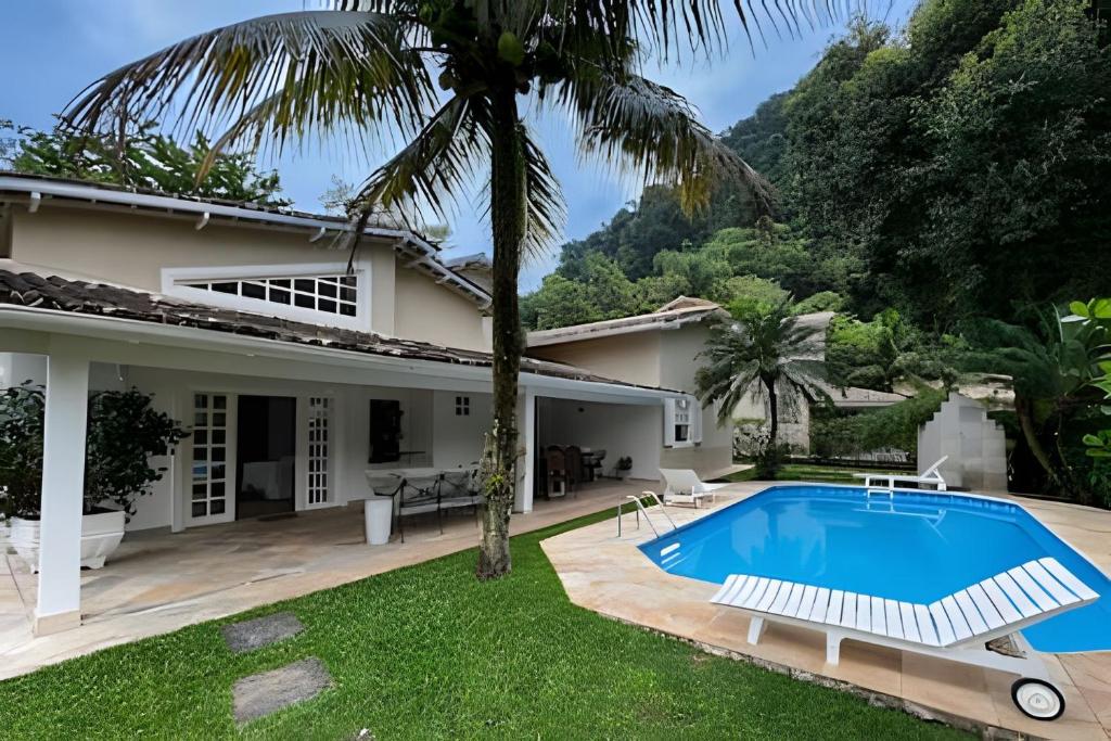 a villa with a swimming pool and a house at Casa com piscina privativa a 100m da Praia de Paúba in São Sebastião