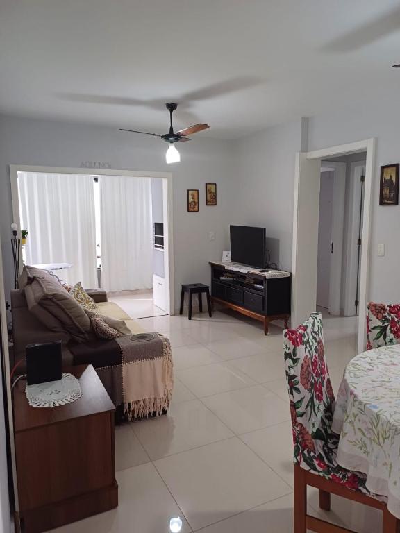 sala de estar con sofá y ventilador de techo en Apartamento aconchegante perto da praia, en Balneário Camboriú