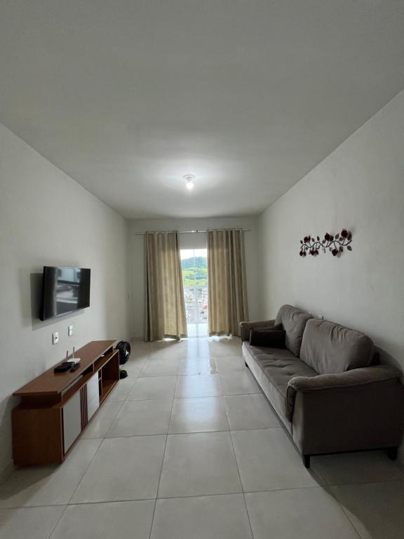 a living room with a couch and a television at Apto Aconchego Capitólio in Capitólio