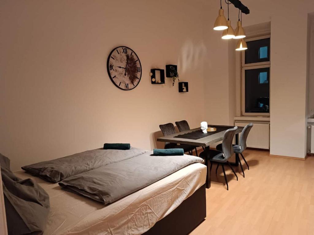 a bedroom with a bed and a table and a clock on the wall at Beautiful Apartments Near Hauptbahnhof in Vienna