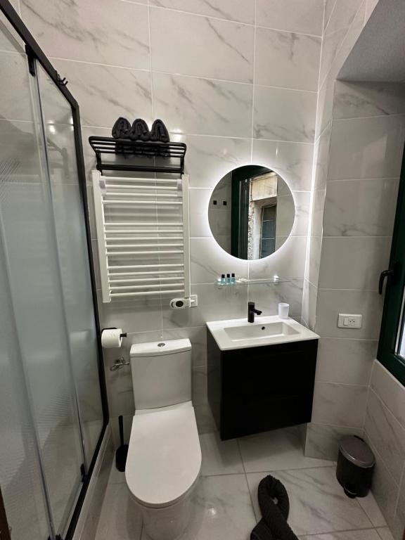une salle de bain avec toilettes, lavabo et miroir dans l'établissement Capodanna, à deux pas des plages au cœur de la vieille ville, à Menton