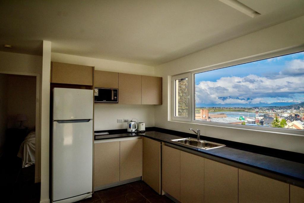 uma cozinha com um frigorífico branco e uma grande janela em Ushuaia Center Apartament Suit em Ushuaia