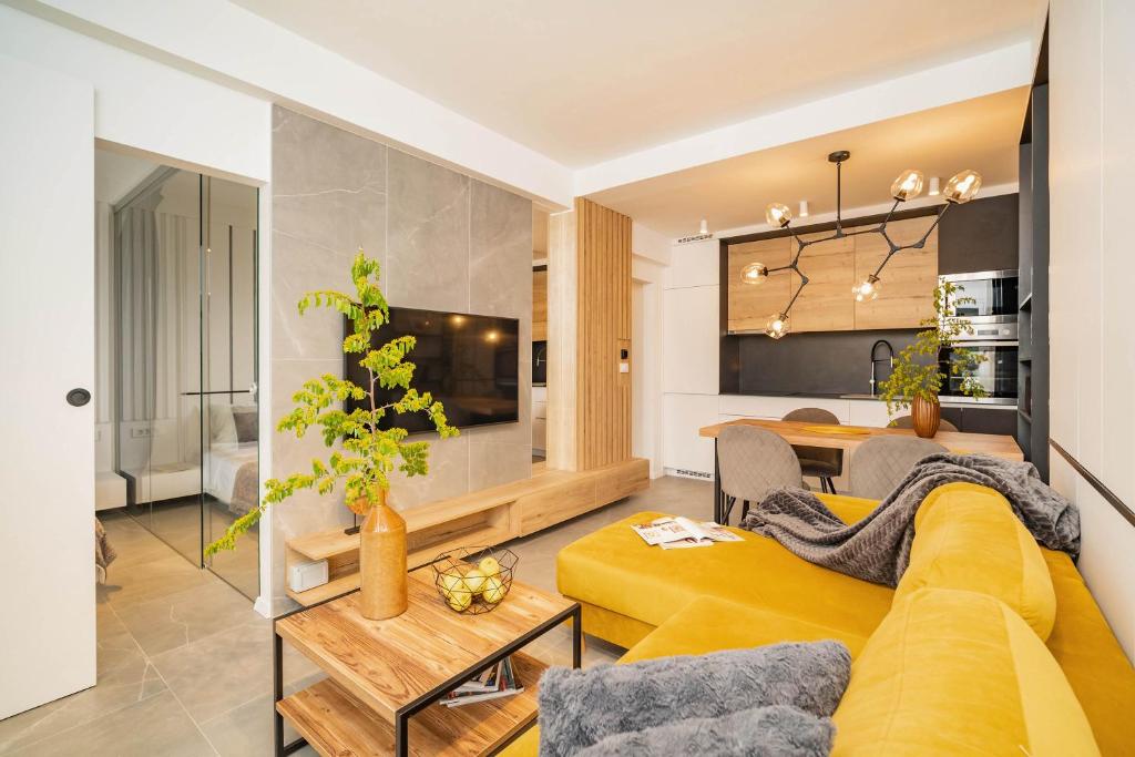 a living room with a yellow couch and a table at AMBER in Rabac