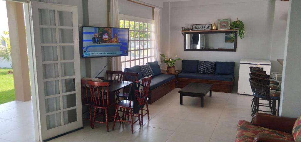 sala de estar con TV, mesa y sillas en ponta do papagaio en Palhoça