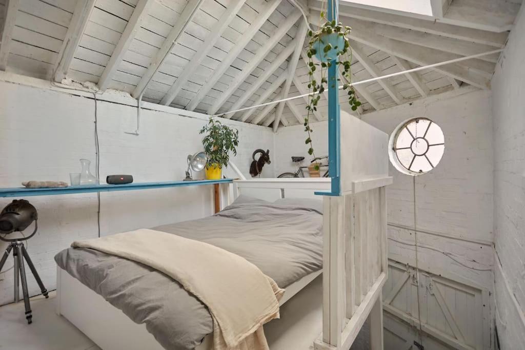 a bedroom with a bed in a white room at Warehouse flat East London in London