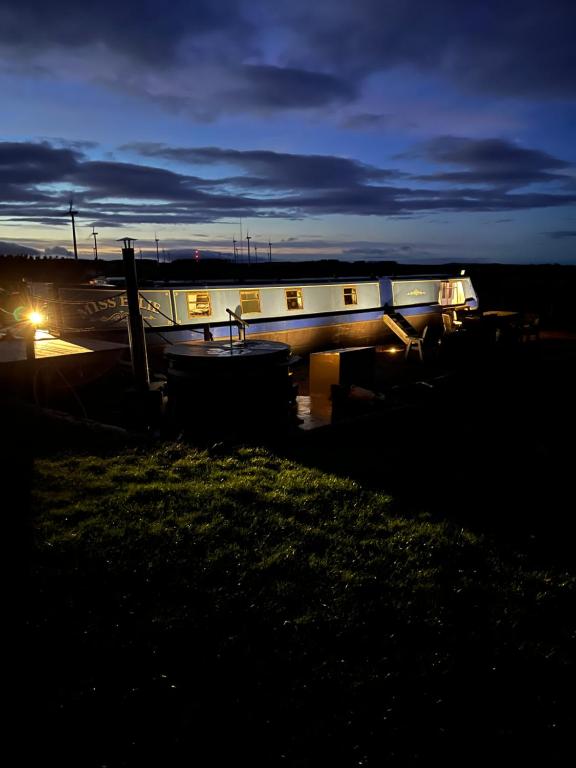 a boat is sitting in a field at night at Middlemoor Farm Holidays in Alnwick