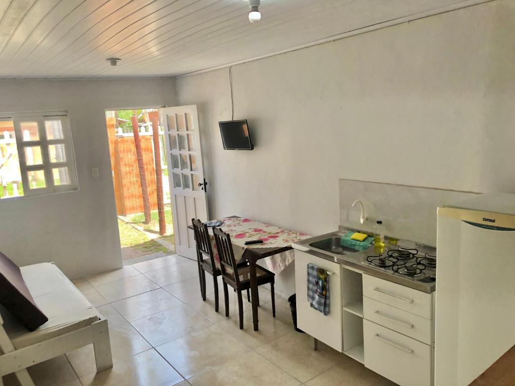 een keuken met een tafel en een fornuis en een eetkamer bij Kitnet a 150m da praia in Rio Grande