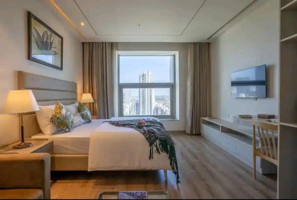 um quarto com uma cama grande e uma janela grande em Luxury Apartment In Gurgaon em Gurgaon