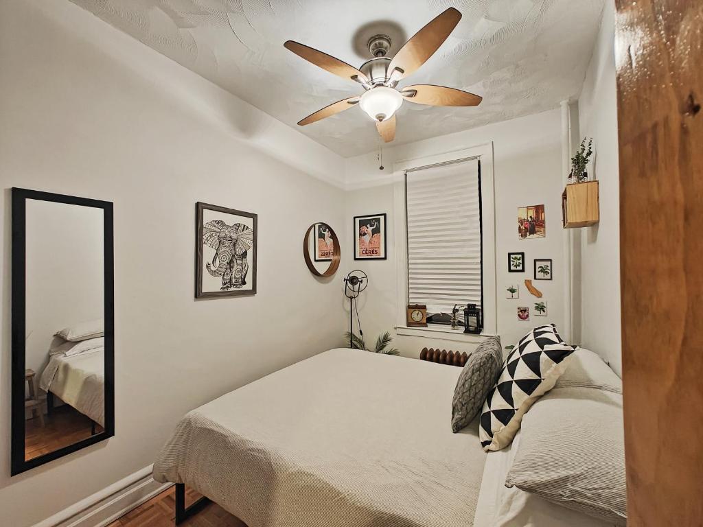 1 dormitorio con ventilador de techo y 1 cama en Two bedroom excellent location, en Queens