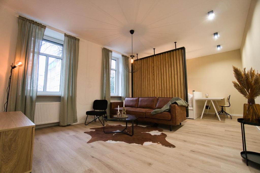 Goethe-Suites: Premium 4 Person Worms city centre Appartment في فورمز: غرفة معيشة مع أريكة وطاولة