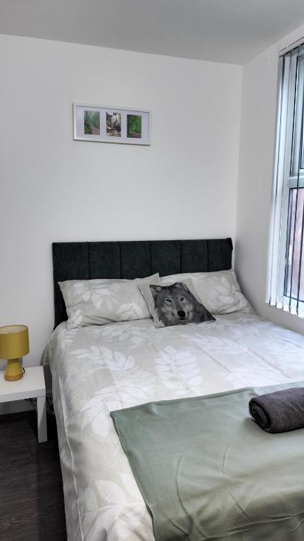 a bedroom with a bed with a dog laying on it at *Modern 1 bedroom Apt next to centre* in Leeds