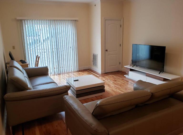 a living room with a couch and a flat screen tv at Amazing 3BR 1Bath Apartment in NYC! in New York