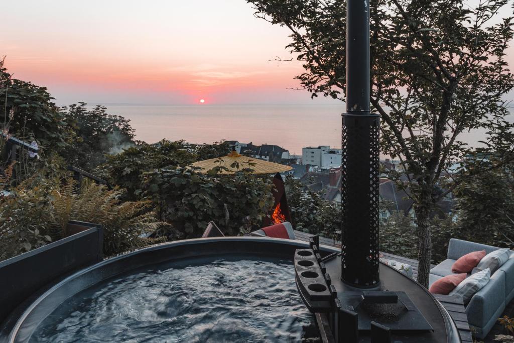 a hot tub with a view of the ocean at sunset at Boutique Beach Retreat in Westward Ho